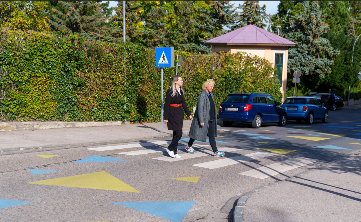 Zwei Personen gehen über einen Zebrastreifen